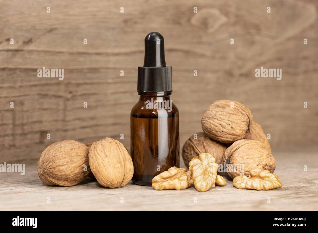 Walnussöl-Stillleben. Braunglasflasche mit Pipettennussöl Stockfoto