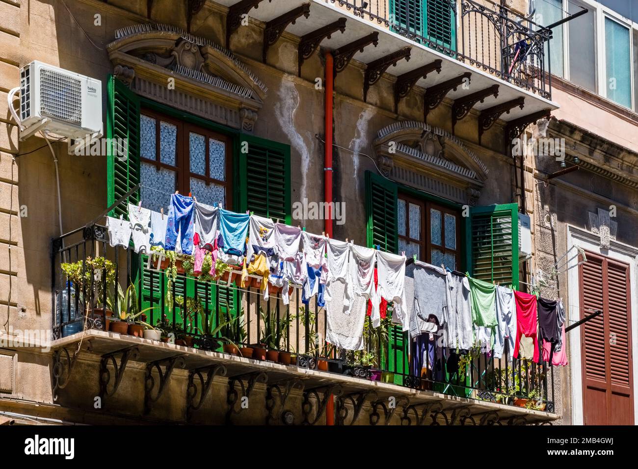 Fassade eines Wohngebäudes in Palermo mit Balkonen und hängender Wäscherei. Stockfoto