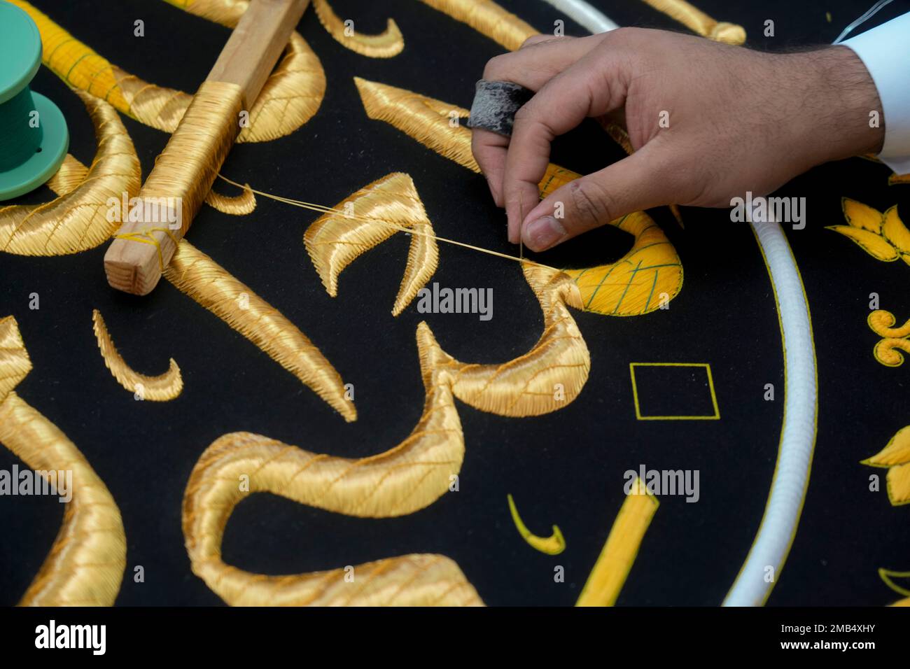 A Saudi worker embroiders Islamic calligraphy, using either pure silver ...