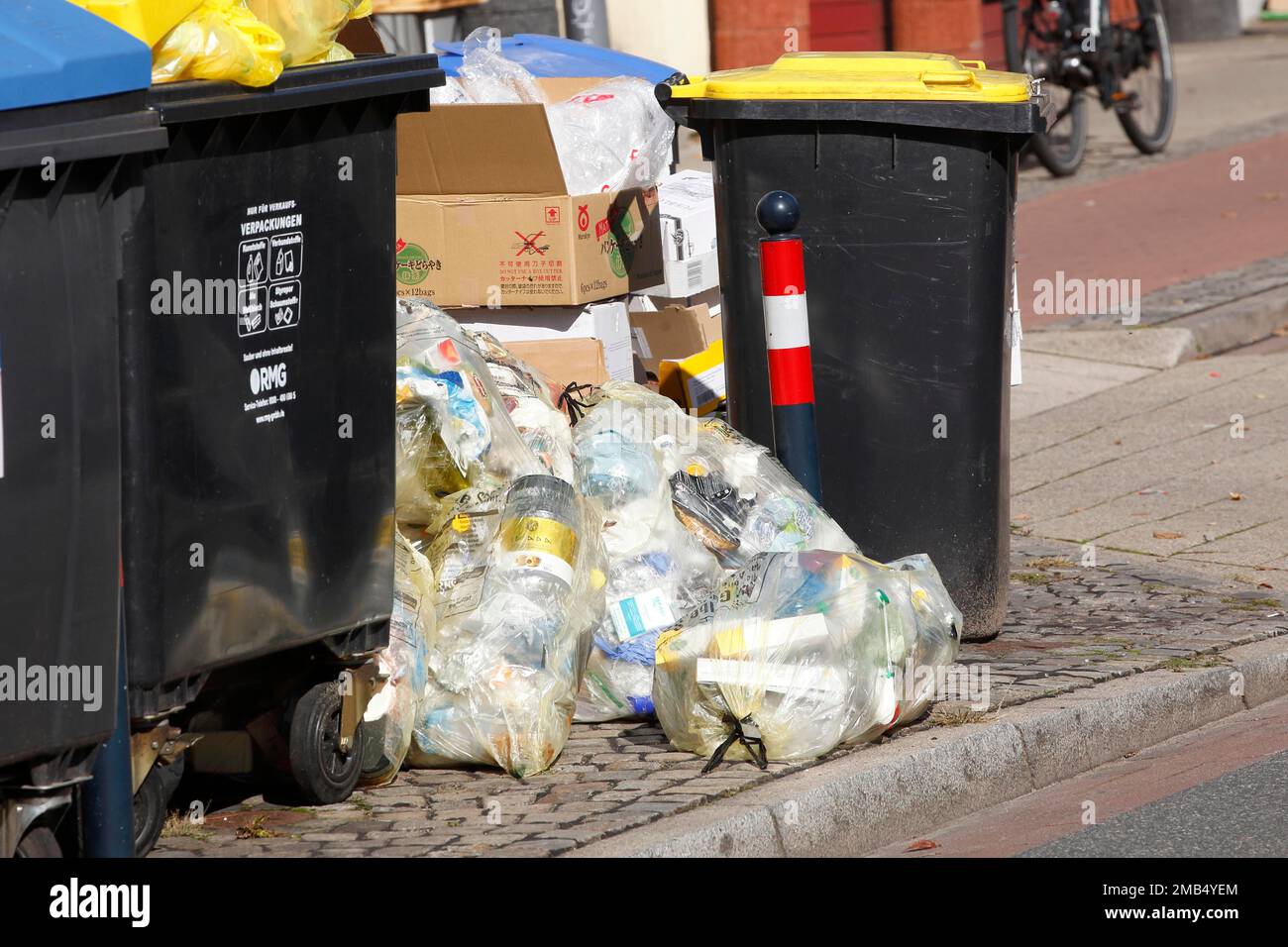 Blaue Behälter für Altpapier und gelbe Säcke und gelbe Behälter für Kunststoffabfälle auf der Straße, Mülltrennung, Deutschland Stockfoto