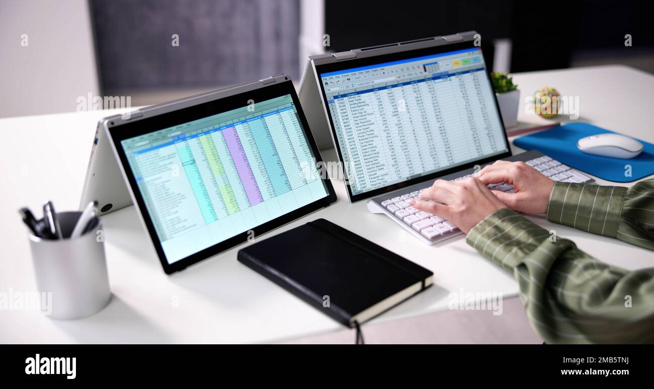 Businesswoman's Hand Examining Spreadsheet on Laptop in Office Stockfoto