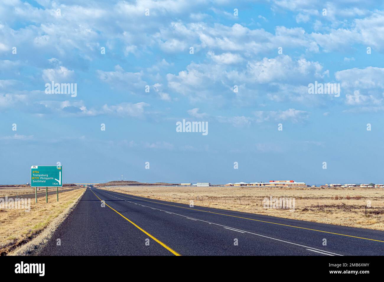 Trompsburg, Südafrika - 7. September 2022: Straße N1 in Trompsburg. Ein Wegweiser, eine Straßenbrücke, das Albert Nzula District Hospital und Three cros Stockfoto