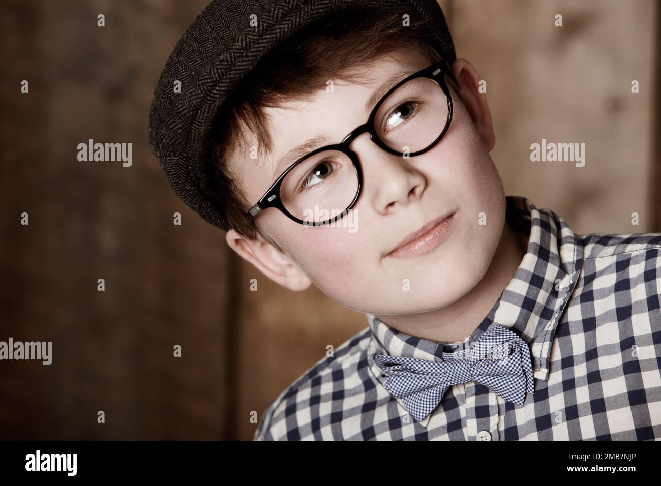 Intelligent und aufmerksam. Ein Junge in Retro-Kleidung, der eine Brille trägt, während er wegsieht. Stockfoto