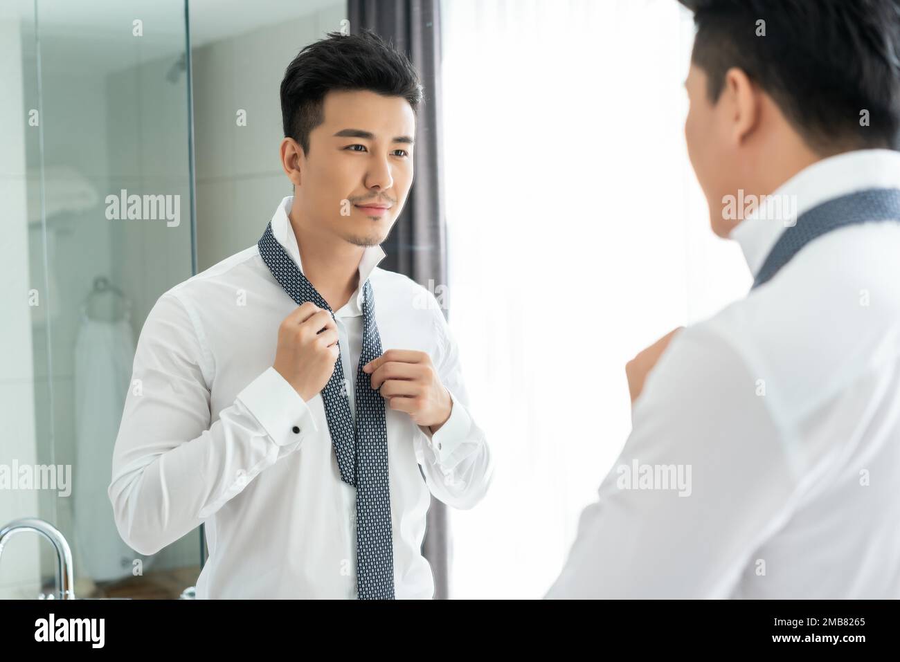Ein junger Mann vor der Spiegelbinde Stockfoto