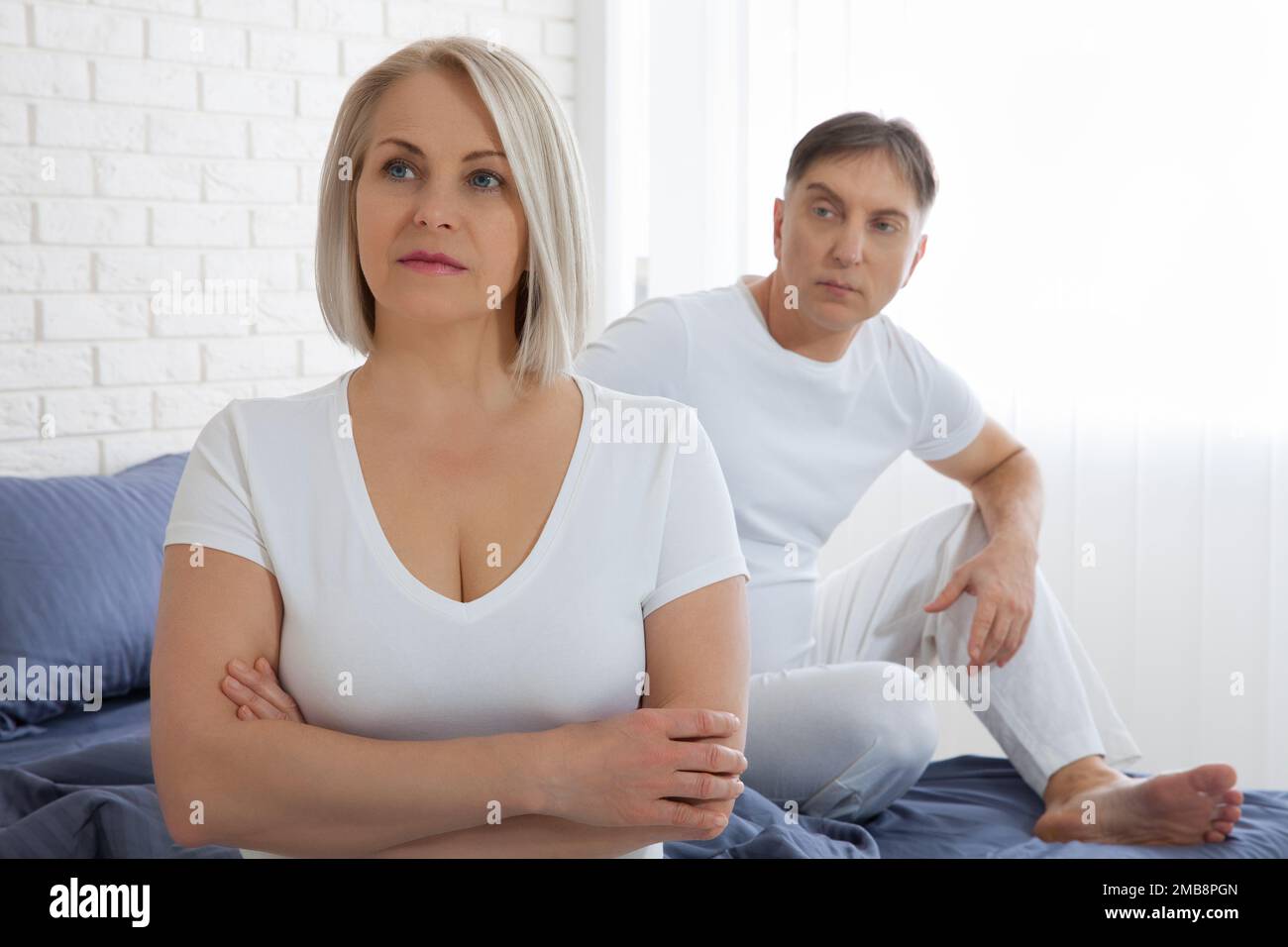 Beleidigte Frau und Mann, die versuchen, sich im Bett zu versöhnen Stockfoto