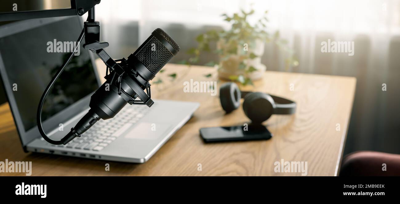 Arbeitsplatz des Content-Erstellers mit Mikrofon, Laptop und Kopfhörern. Heimstudio für Podcasting, Online-Streaming, Radioübertragung. Banner mit Polizist Stockfoto