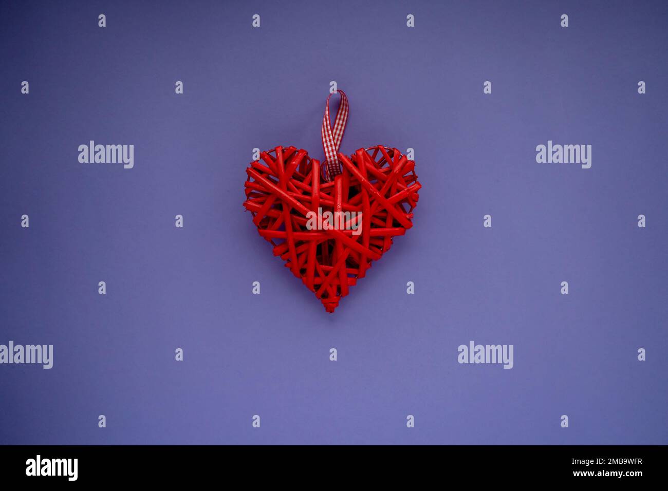 Valentinskarte. Eine leuchtend rote Figur in Form eines Herzens, das aus Ästen in der Mitte der Karte gewebt ist Stockfoto