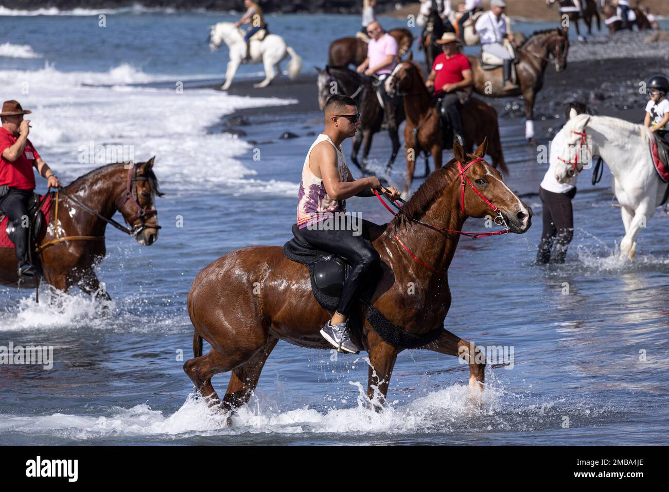 Costa Adeje, Teneriffa, Kanarische Inseln, 20. Januar 2023. Am Strand Playa Enramada können die Reiter während der Fiesta von San Sebastian ins Meer steigen, die zum ersten Mal seit 2020 aufgrund der Beschränkungen der Covid-Pandemie zurückkehrt. Die jährliche Fiesta in La Caleta an der Costa Adeje wird von Einheimischen und Touristen genossen, die sich versammeln, um die vielen Pferde zu sehen, die zum Baden im Meer am Strand Playa Enramada kommen. Kredit: Phil Crean A/Alamy Live News Stockfoto