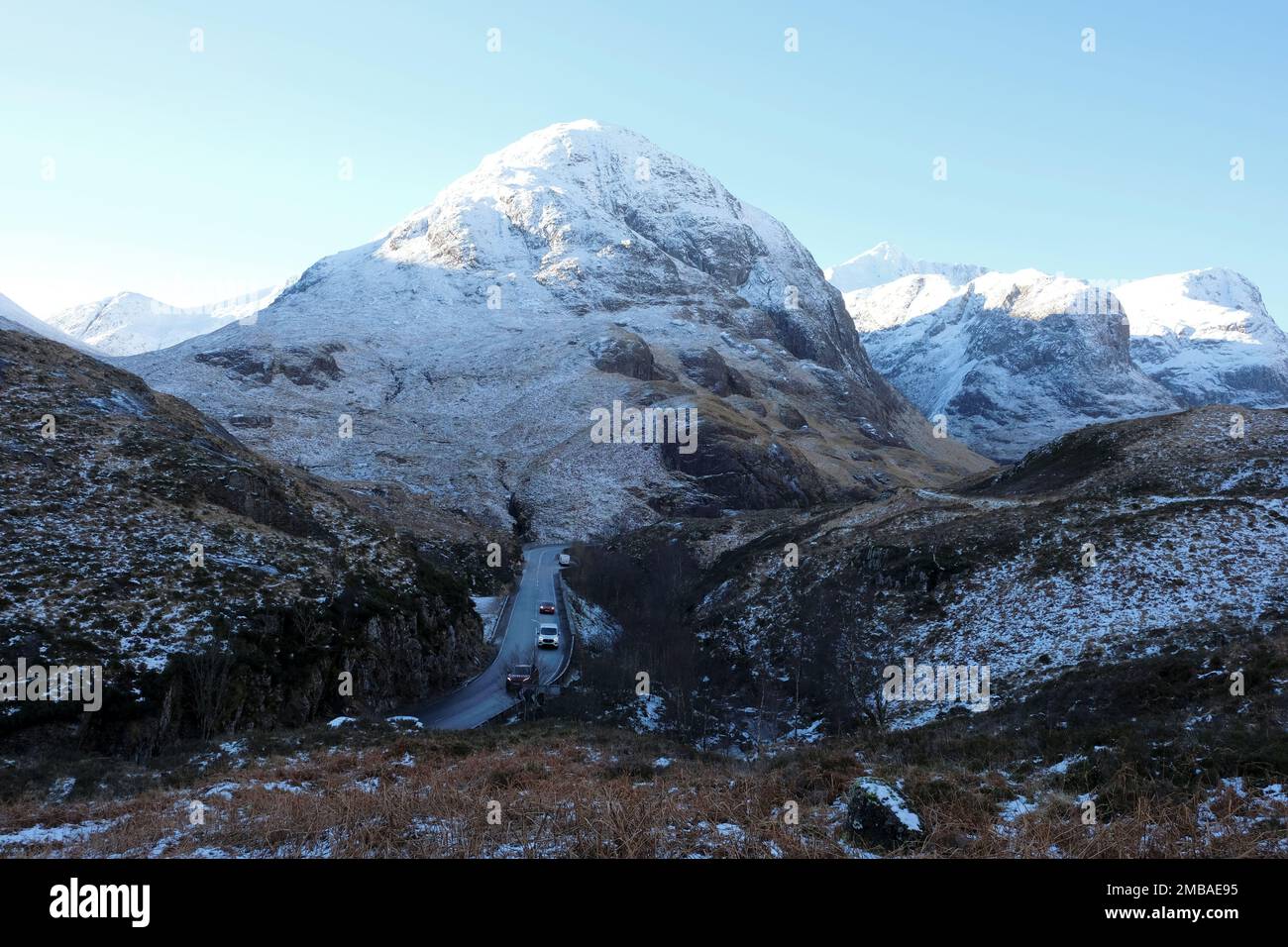 Glencoe, Schottland, Großbritannien. 20. Januar 2023 Der klare blaue Himmel, Sonnenschein und schneebedeckte Hänge der Berge rund um Glencoe bieten eine Kulisse für schwierige Fahrbedingungen auf der eisigen Hauptstraße A82 North. Kredit: Craig Brown/Alamy Live News Stockfoto