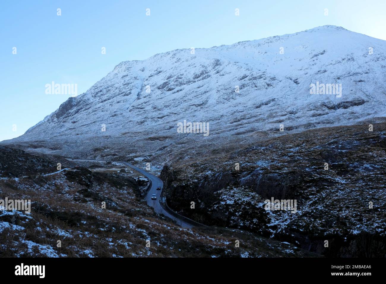 Glencoe, Schottland, Großbritannien. 20. Januar 2023 Der klare blaue Himmel, Sonnenschein und schneebedeckte Hänge der Berge rund um Glencoe bieten eine Kulisse für schwierige Fahrbedingungen auf der eisigen Hauptstraße A82 North. Kredit: Craig Brown/Alamy Live News Stockfoto