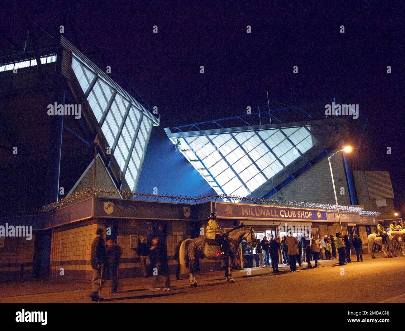 The Den, Zampa Road, South Bermondsey, Lewisham, Greater London Authority, 2011. Die beleuchtete nordwestliche Ecke des Stadions Den, von der Zampa Road aus bei Nacht gesehen, mit montierten Polizisten und Fußballfans vor dem Eingang. Das Den wurde 1993 als New London Stadium, später als New Den, eröffnet. Hier befindet sich der Millwall Football Club. Stockfoto