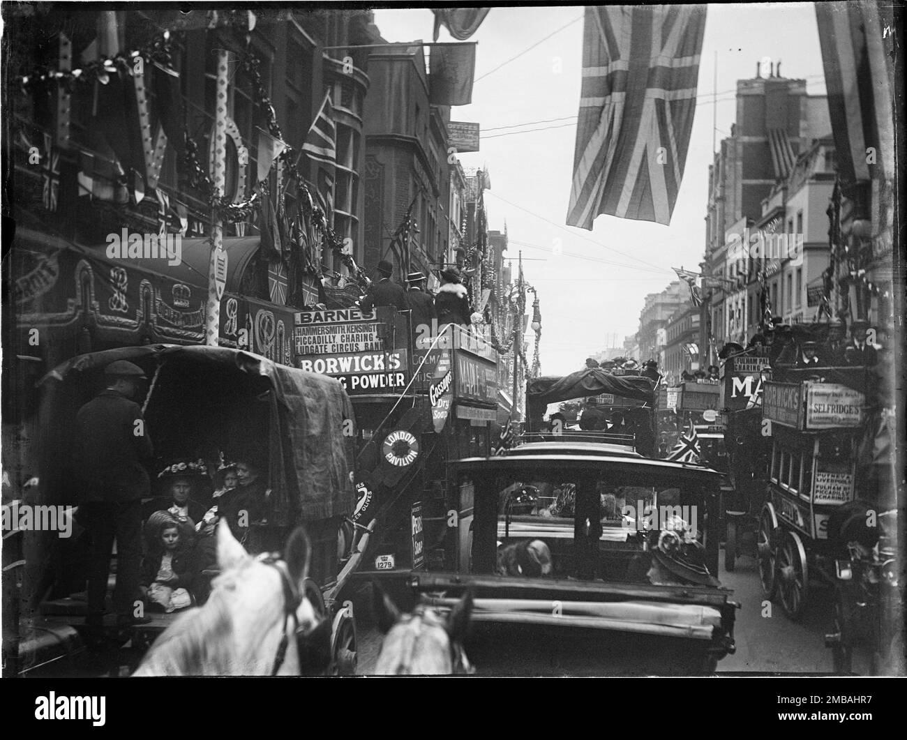 Strand, Strand, City of Westminster, Greater London Authority, 1911. Ein Blick vom Pferdetransport auf Strand zeigt die umliegende Straße voller Busse und Taxis und die Gebäude, dekoriert mit Flößen und Flaggen zur Krönung von König George V. und Königin Mary. Die Krönungsdekoration in London. Die Straße ist mit Flaggen und Fähnchen geschmückt, die für die Krönung von König George V. und Königin Mary am 22. Juni 1911 bestimmt sind. Stockfoto