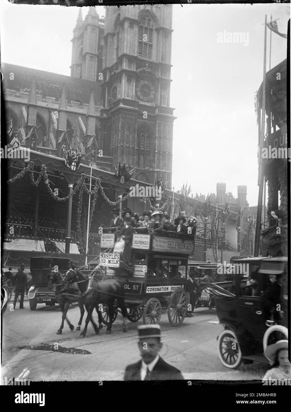 Westminster Abbey, Westminster, City of Westminster, Greater London Authority, 1911. Eine große Tribüne vor der Westminster Abbey zur Krönung von König George V und Königin Mary und ein Pferdebus mit „Krönungsroute“, der mit beladenen Passagieren vorbeifährt. Die Krönungsdekoration in London. Die große Tribüne, dekoriert mit Flöten, war eine von mehr als fünfzig errichtet entlang der Strecke zur Krönung von König George V. und Königin Mary am 22. Juni 1911. Stockfoto