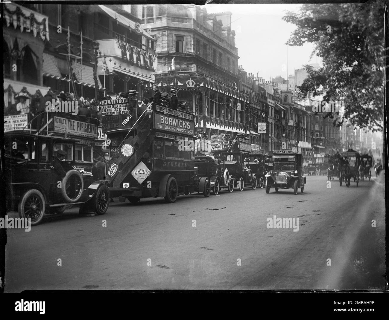 Piccadilly, City of Westminster, Greater London Authority, 1911. Blick auf Taxis und Busse mit offenem Oberdeck auf Piccadilly. Vom Fotografen aufgenommen, um Krönungsdekorationen in London zu zeigen. An der Vorderseite der Gebäude für die Krönung von König George V. und Königin Mary am 22. Juni 1911 sind Flaggen und Fahnen zu sehen. Stockfoto