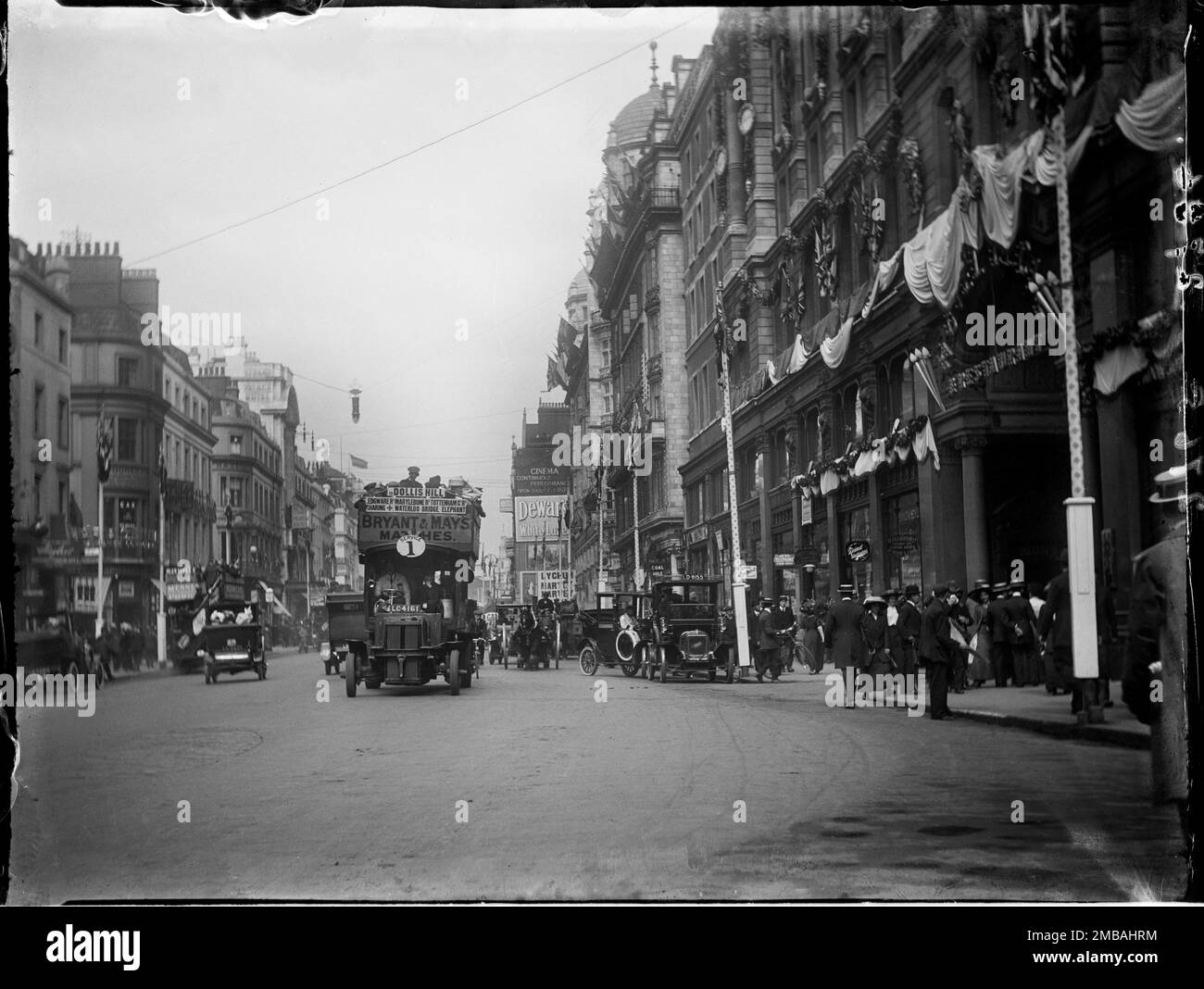 Hotel Cecil, The Strand, City of Westminster, Greater London Authority, 1911. Vor dem Hotel Cecil on Strand befindet sich eine lebhafte Straßenszene, in der Autos, Fußgänger und ein offener Bus in Richtung Vordergrund gezeigt werden. Das Foto ist eines der Fotos, die der Fotograf aufgenommen hat, um die Krönungsdekorationen in London zu zeigen. An der Vorderseite des Hotels befinden sich Flaggen und Fahnen zur Krönung von König George V. und Königin Mary am 22. Juni 1911. Stockfoto