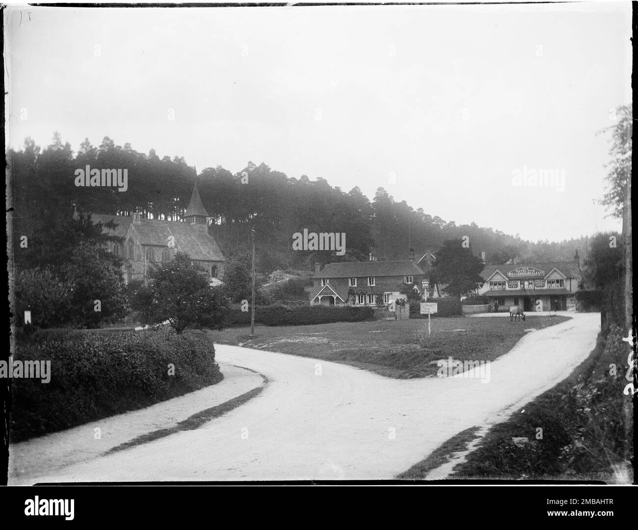 Holmbury St. Mary, Shere, Guildford, Surrey, 1912. Ein allgemeiner Blick nach Süden über das Dorfgrün in Holmbury St Mary, in Richtung St. Mary's Church und Royal Oak Pub mit einem bewaldeten Hügel dahinter. Stockfoto