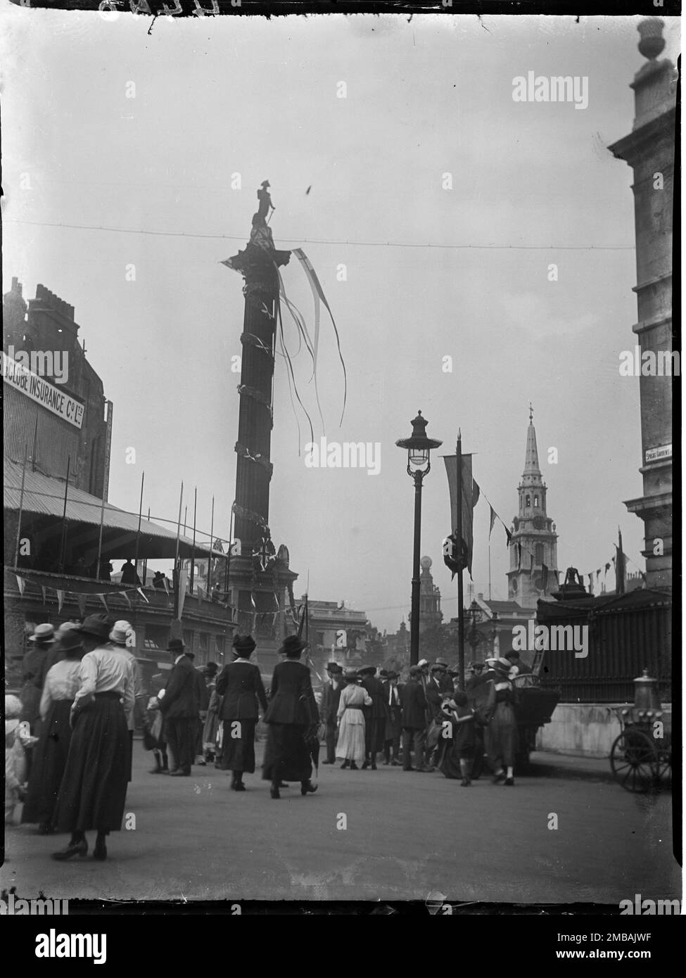 Trafalgar Square, St. James, Westminster, City of Westminster, Greater London Authority, 1919. Blick auf die Nelson-Säule und den Kirchturm von St. Martin in the Fields, der die Menschen auf dem Weg zum Trafalgar Square und seinen Friedensdekorationen zeigt. Dieses Foto gehört zu einer Gruppe, die der Fotograf am 18., 21. &Amp; 23. Juli 1919 aufnahm und die Friedensdekorationen aufnahm, die zum Friedenstag am 19. Juli 1919 in London zur Feier des Endes des 1. Weltkriegs errichtet wurden. Stockfoto