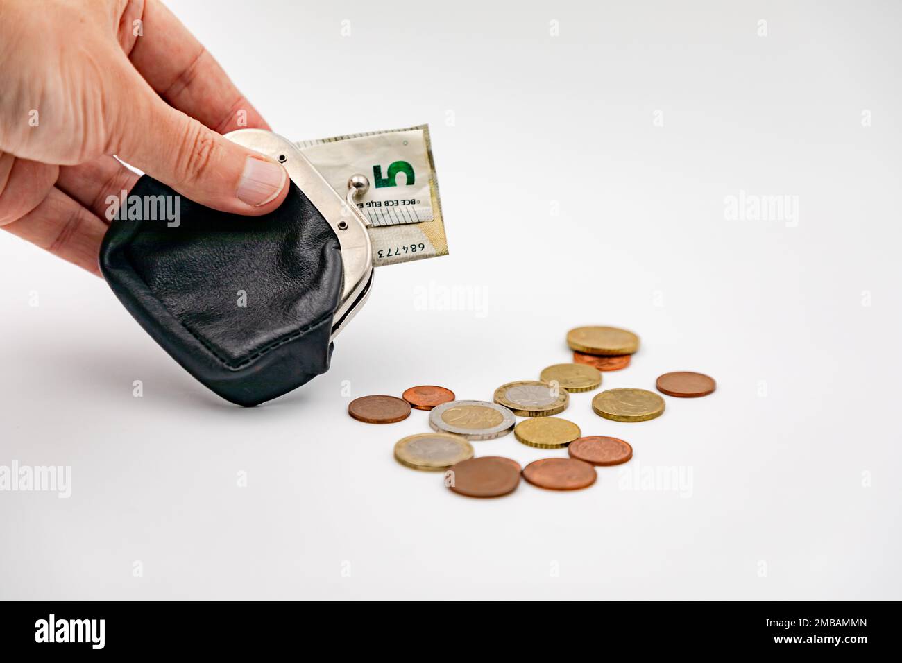 Hand mit Geldbörse und kleinen Euro-Banknoten und Euro-Münzen Stockfoto