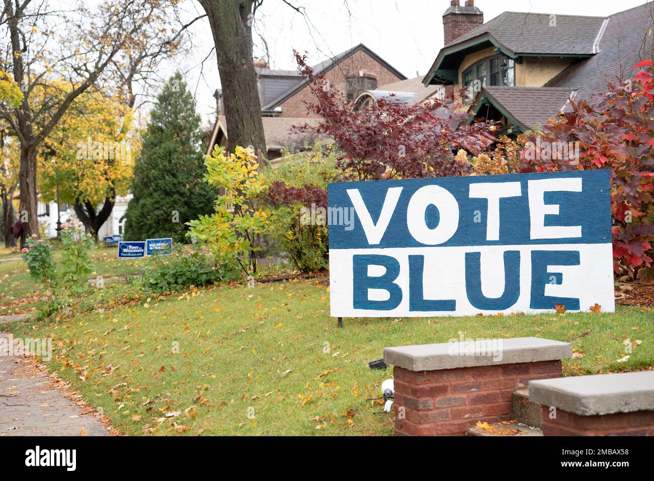 Ein großes handbemaltes Hofschild mit der Aufschrift VOTE BLUE in großen Buchstaben wird im Vorgarten aufgestellt Stockfoto