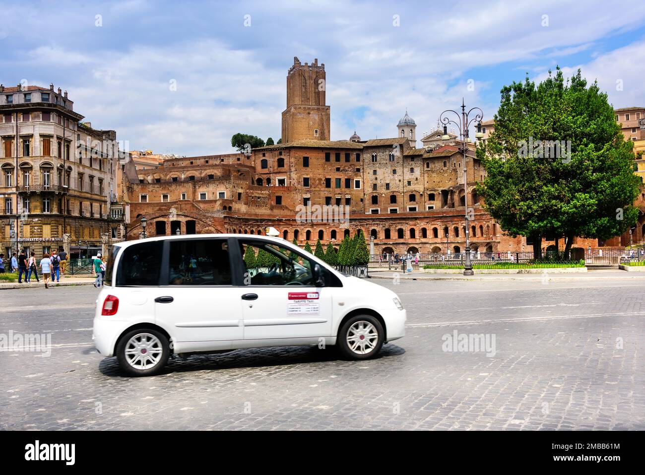 Rom, Italien - 10. Juni 2016: Taxifahrer auf einer belebten Straße mit Fußgängern und mit antiker römischer Architektur gesäumt. Stockfoto