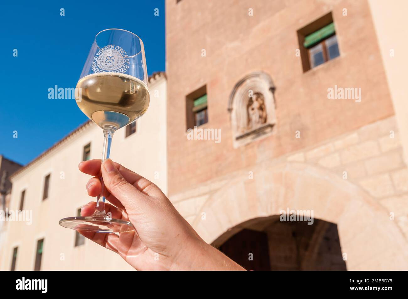 Halten Sie ein Glas Weißwein vor dem Eingang zum Monestir de Poblet. Monestir de Poblet, Katalonien, Spanien Stockfoto