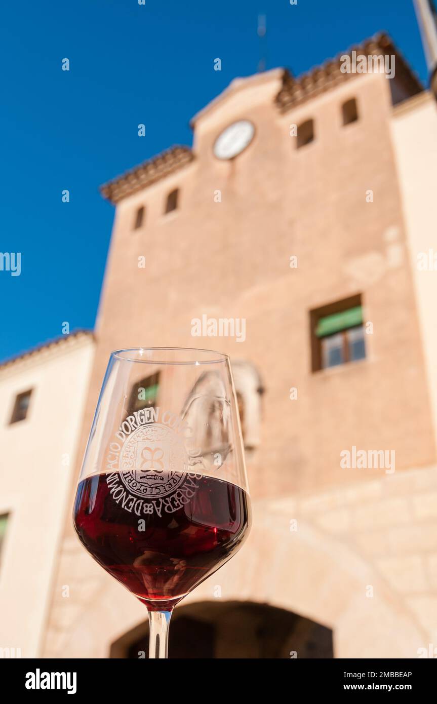 Halten Sie ein Glas Rotwein vor dem Eingang zum Monestir de Poblet. Monestir de Poblet, Katalonien, Spanien Stockfoto
