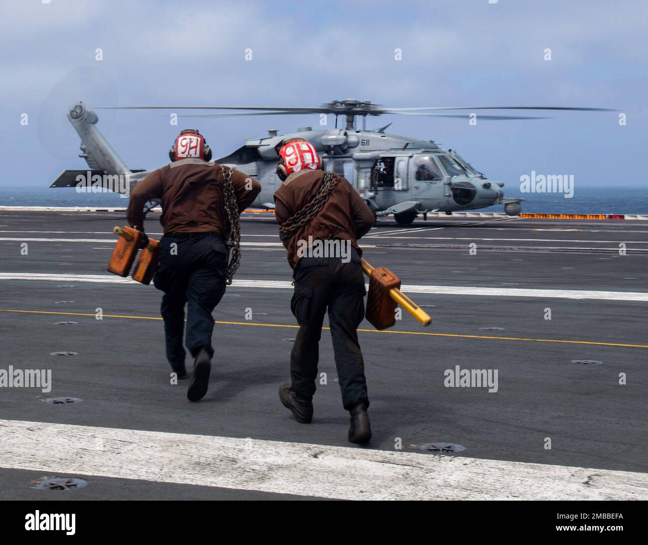 220614-N-YS933-1320 SEELEUTE IM PAZIFISCHEN OZEAN (14. Juni 2022) bereiten sich darauf vor, einen MH-60s Sea Hawk Hubschrauber von den „Indians“ des Helicopter Sea Combat Squadron (HSC) 6 an Bord des Flugzeugträgers USS Nimitz (CVN 68) zu blockieren und zu ketten. Nimitz ist im 3.-Flottenbereich der USA unterwegs. Stockfoto