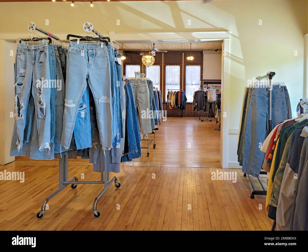 Jeans in Blau-Jeans in Used-Mode-Optik, die in einem Geschäft an Kleiderständern hängt Stockfoto