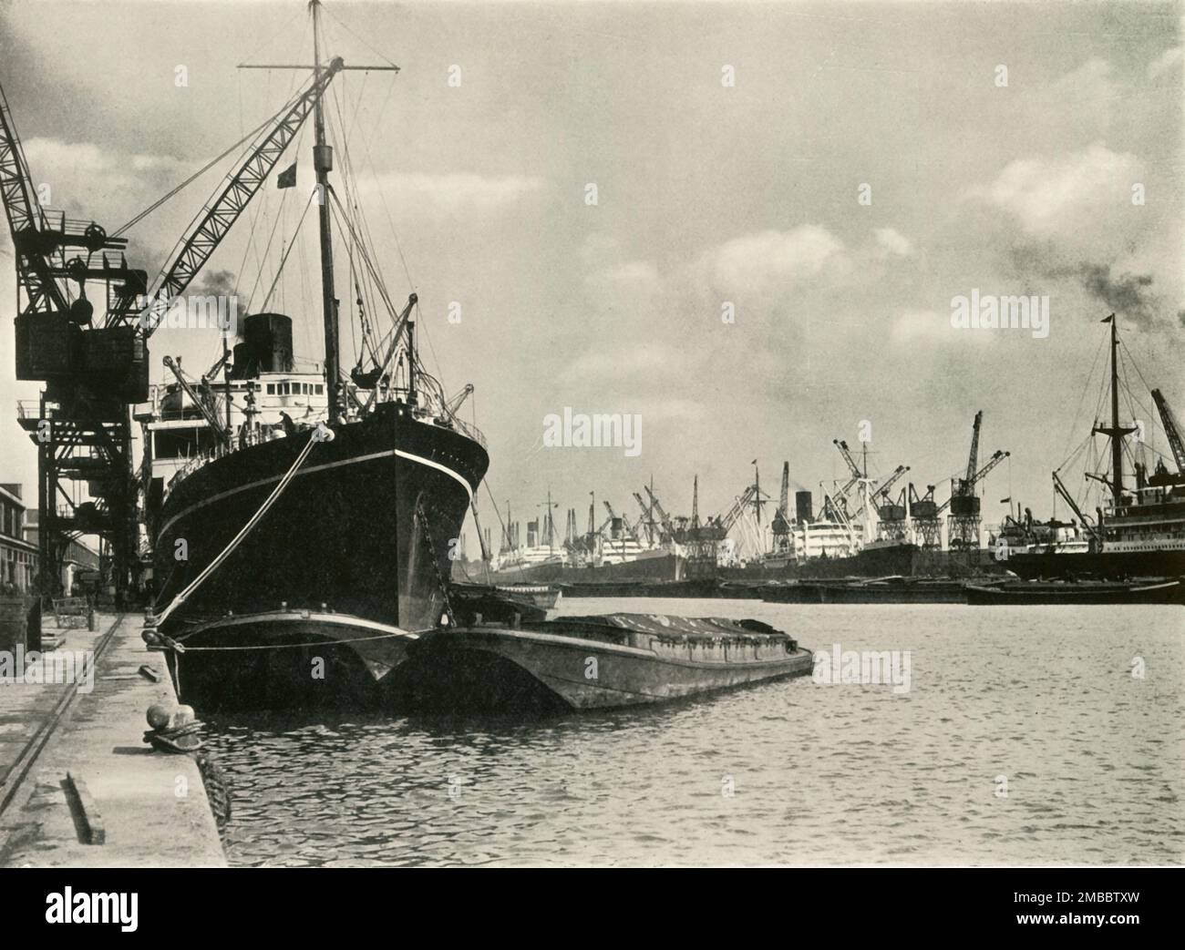 "Händler bringen Waren von Schiffen jeder Nation" Schiffe entlang der Kai, King George V Dock, 1937. Frachtschiffe auf der Themse in London. Aus "The Said Noble River", von Alan Bell. [Port of London Authority, London, 1937] Stockfoto