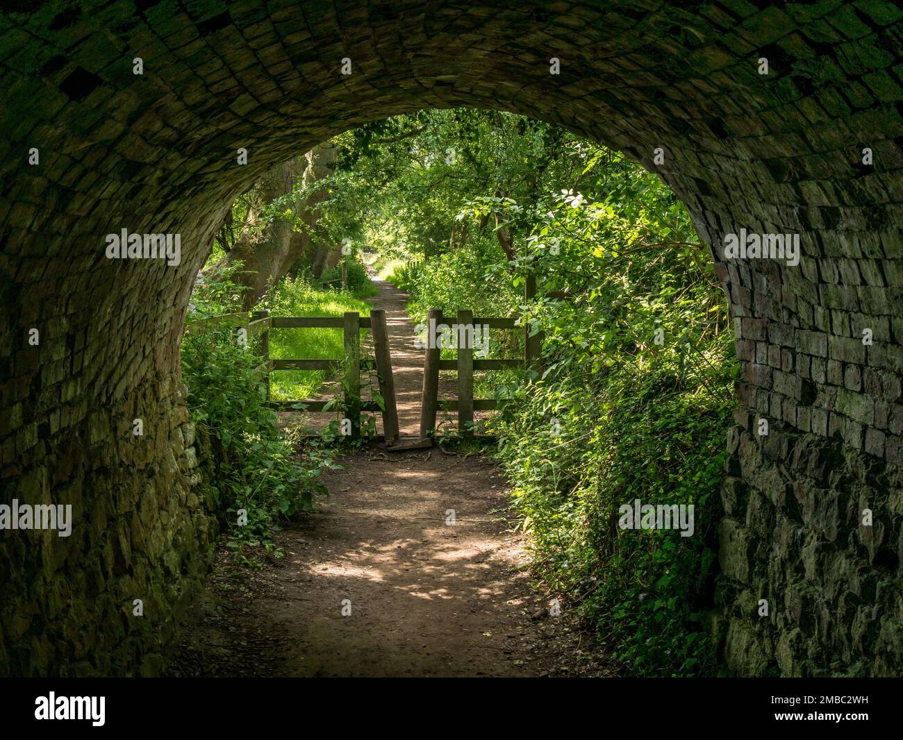 Verlassen Sie die Straßenbahnhaltestelle, den steingesäumten Tunnel, Fußweg und Radweg, Ticknall Limeyards, Derbyshire, England, Großbritannien Stockfoto