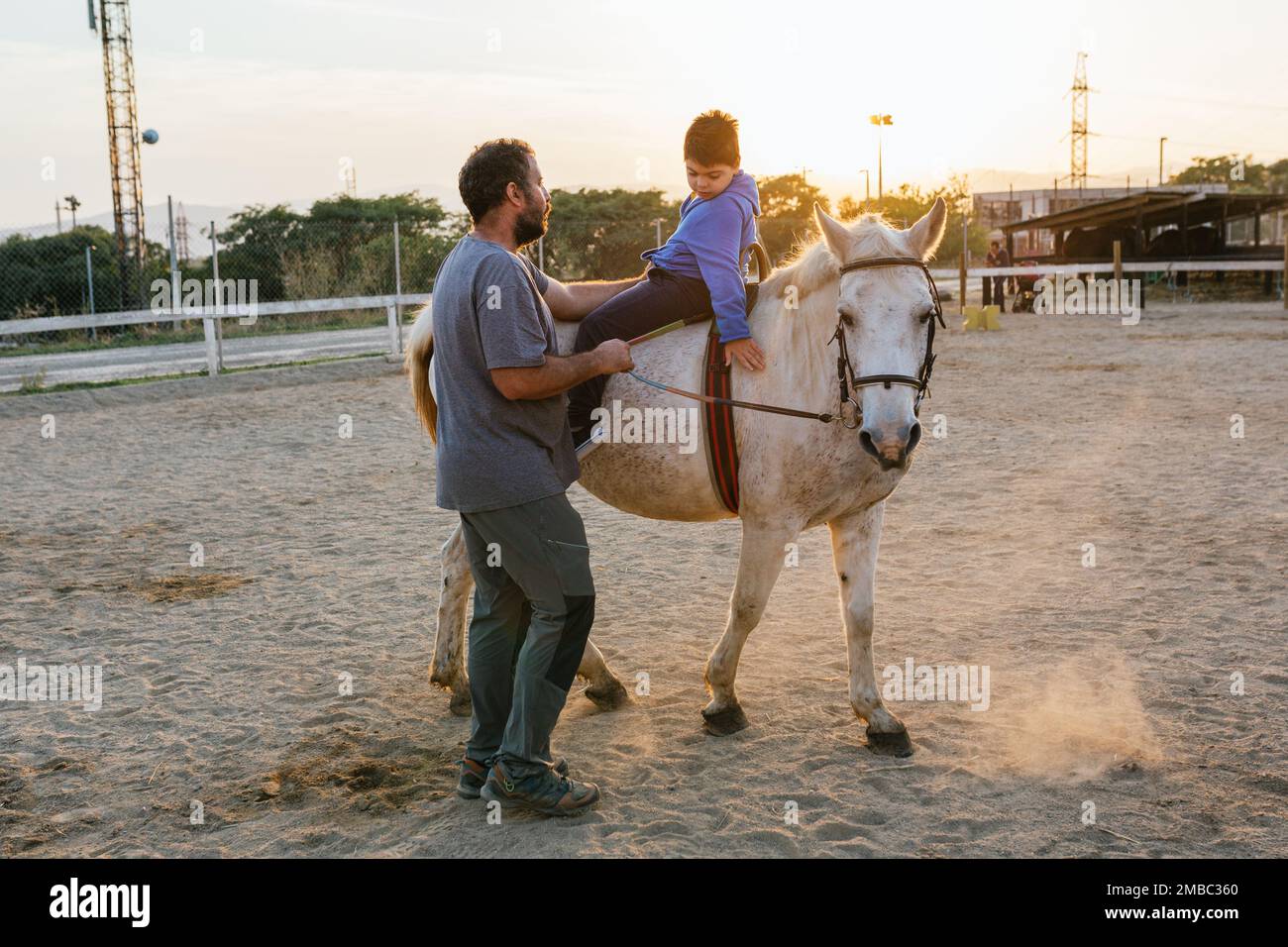 Ein behinderter Junge streichelt ein Pferd während einer Pferdetherapie Stockfoto
