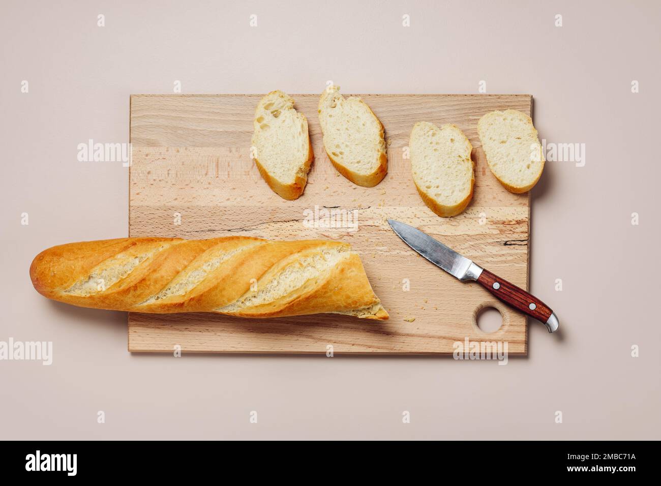 Geschnittenes Baguette auf einem Schneidebrett, Draufsicht. Stockfoto
