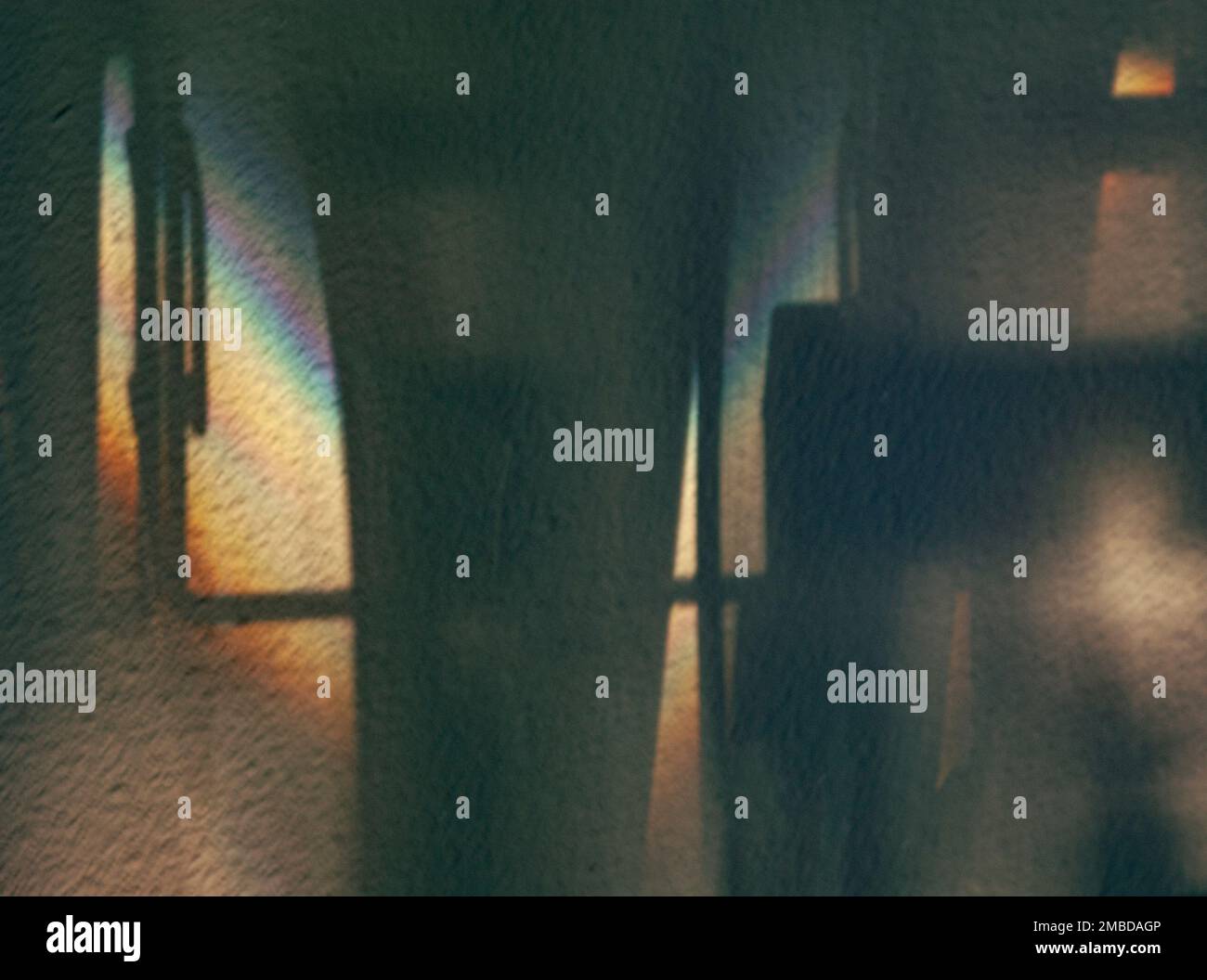 Schatten und Morgenlicht schaffen Visionen moderner Strukturen und Stützen. Die Stuckwand ist in hellen und dunklen Regenbogenfarben gehalten und reflektiert. Stockfoto