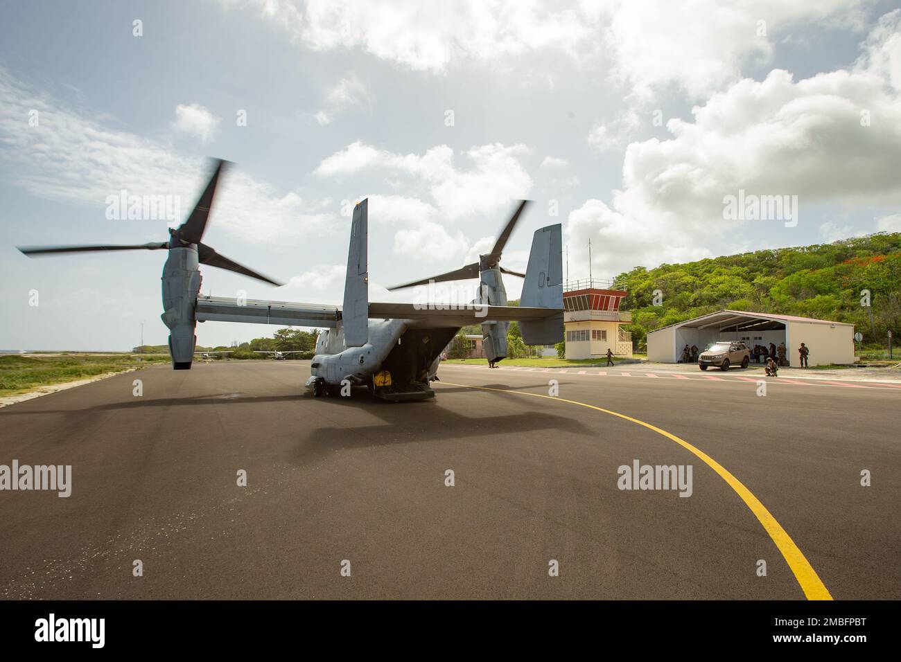 Eine MV-22B Osprey, die der Marine Medium Tiltrotor Squadron (VMM) 266 zugeteilt wurde, bereitet sich auf den Start vor, da Mitglieder der französischen Streitkräfte eine Landezone während der französisch-karibischen Übung Caraibes 22 in Guadeloupe am 15. Juni 2022 sichern. Caraibes 22 ist eine von Frankreich geführte, groß angelegte gemeinsame Ausbildungsübung in der Karibik, bei der Marine-, Luft- und Landressourcen der französischen, US- und regionalen Streitkräfte eingesetzt werden, die sich auf simulierte Naturkatastrophen konzentrieren. VMM-266 ist eine dem 2. Marine Aircraft Wing unterstehende Einheit, dem Luftfahrt-Kampfelement der II Marine Expeditionary Force. Stockfoto