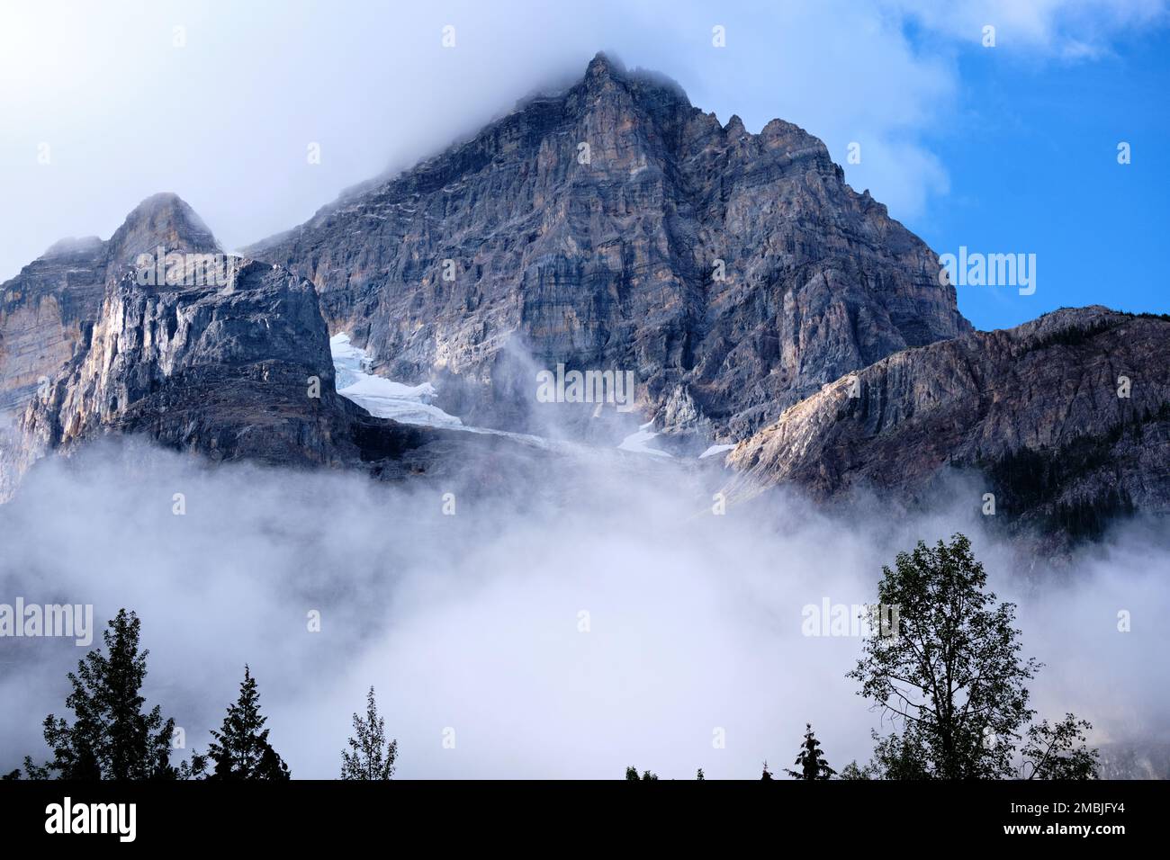 Während die Wolken im Yoho National Park klar werden, taucht der felsige Gipfel des Mount Stephen auf und zeigt kleine Gletscher auf der Nordseite. Stockfoto