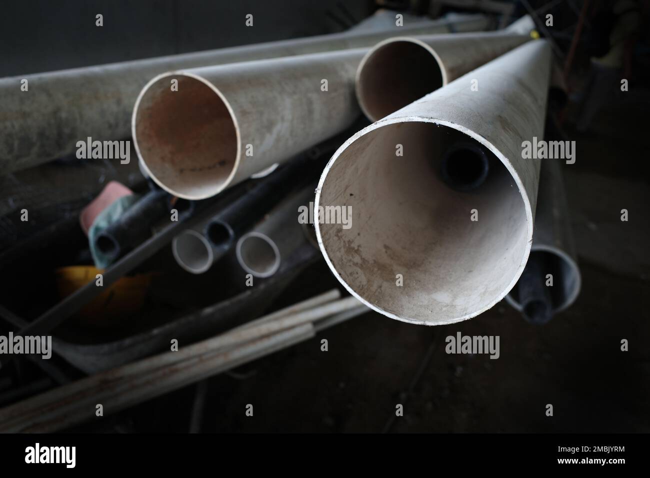 Nahaufnahme von Rohren aus weichmacherfreiem Polyvinylchlorid (UPVC), die für Rohrleitungen verwendet werden, die in einer Bauumgebung übereinander liegen Stockfoto