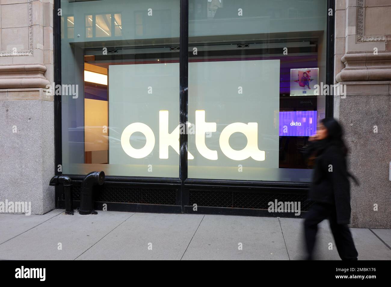 Eine Person geht am Okta Experience Center, 920 Broadway, in New York City vorbei Stockfoto