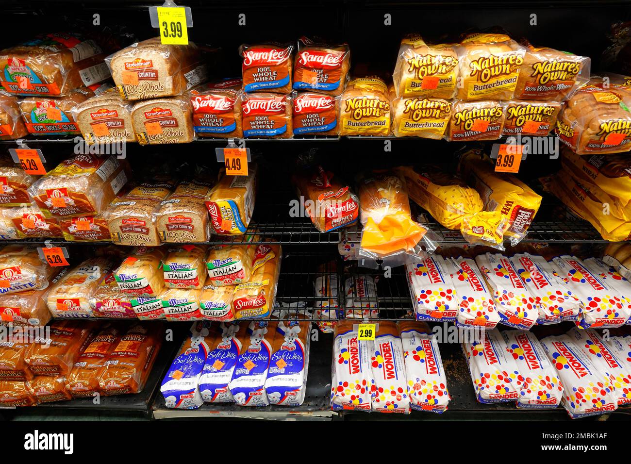 Verschiedene Sorten von in Massenproduktion hergestelltem Weißbrot auf einem Regal eines amerikanischen Supermarkts. Stockfoto