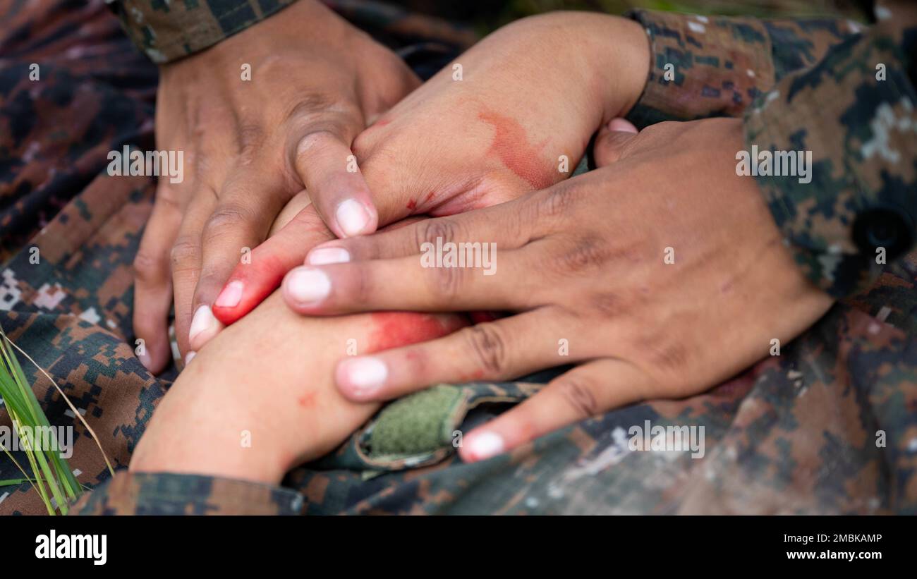 Ein Sanitäter aus El Salvador hilft einem simulierten Überlebenden eines Flugzeugabsturzes, die Blutung einer Wunde zu stoppen, damit sie nach anderen Verletzungen suchen können, bevor sie sie an einen sicheren Ort am Ilopango Air Base, El Salvador, am 16. Juni 2022 transportiert werden. Resolute Sentinel 22 ist eine Übung, die militärische medizinische Fachkräfte auf den Einsatz und die Durchführung gemeinsamer Operationen unter strengen Bedingungen vorbereiten soll. Stockfoto