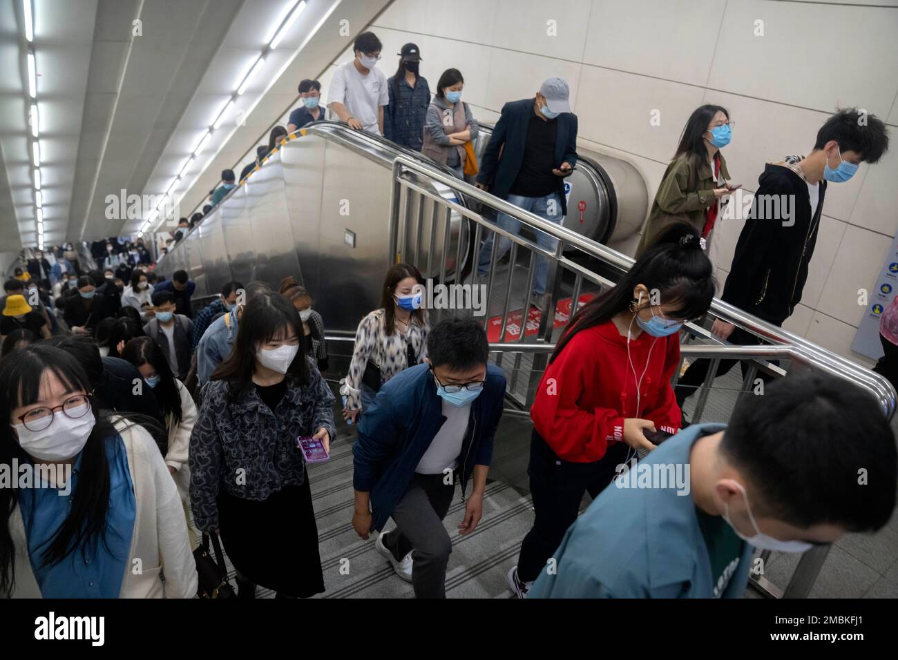 FILE - Commuters wearing face masks walk in a subway station in Beijing, Friday, April 22, 2022. Beijing is on alert after 10 middle school students tested positive for COVID-19 on Friday, in what city officials said was an initial round of testing. (AP Photo/Mark Schiefelbein, File) Stockfoto
