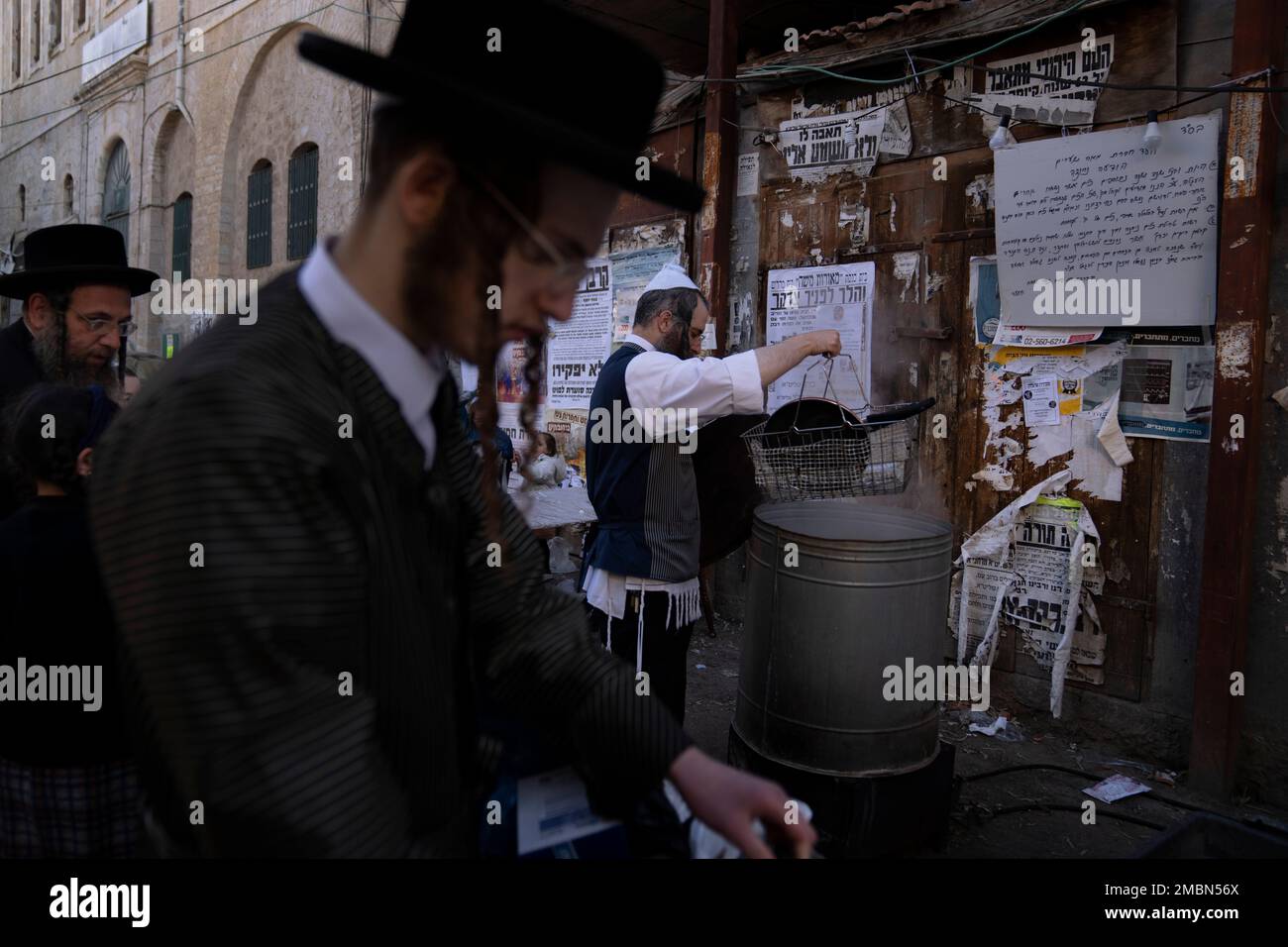 An ultraOrthodox Jewish man dips cooking utensils in boiling water to