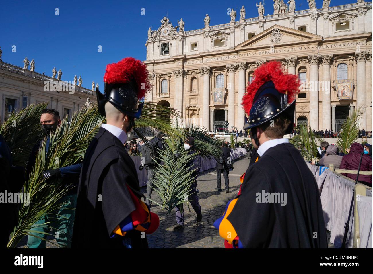 Palm tree branches are distributed to people as they wait for the arrival of Pope Francis to celebrate Palm Sunday Mass in St. Peter's Square at the Vatican, Sunday, April 10, 2022. The Roman Catholic Church enters Holy Week, retracing the story of the crucifixion of Jesus and his resurrection three days later on Easter Sunday. (AP Photo/Greorio Borgia) Stockfoto