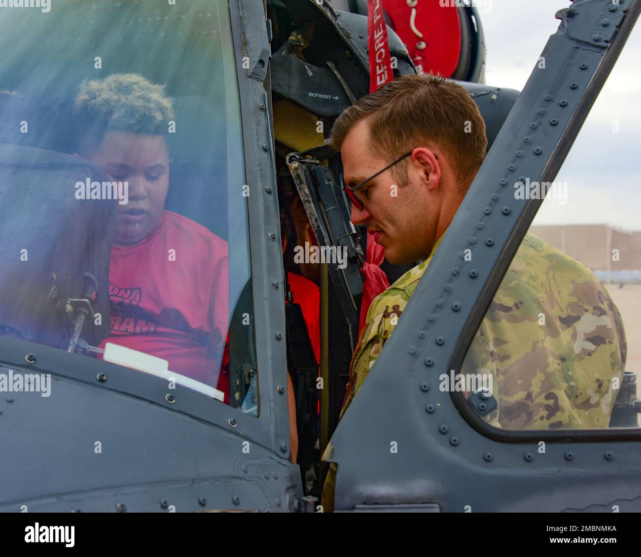 USA Air Foce Staff Sgt. Colby Cantrell, 55. Rettungsschwadron HH-60G Pave Hawk Flying Crew Chief, informiert einen jungen Mann auf der Pavehawk während einer Basistour für das Youth Impact Program auf dem Luftwaffenstützpunkt Davis-Monthan, Arizona, 17. Juni 2022. Das Programm arbeitet mit Militär- und Universitätsleitern zusammen, um akademische und Führungskompetenzen bei benachteiligten gefährdeten Mittelschülern zu verbessern. Stockfoto