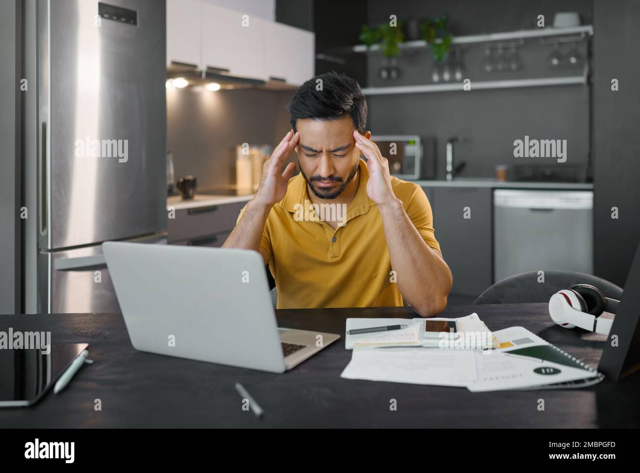 Geschäftsmann, Heimbüro und Kopfzerbrechen mit einem Notebook in der Küche für seo-Datenanalyse, Kleinunternehmen oder Goal. Digitaler Unternehmer, Werbetexte Stockfoto