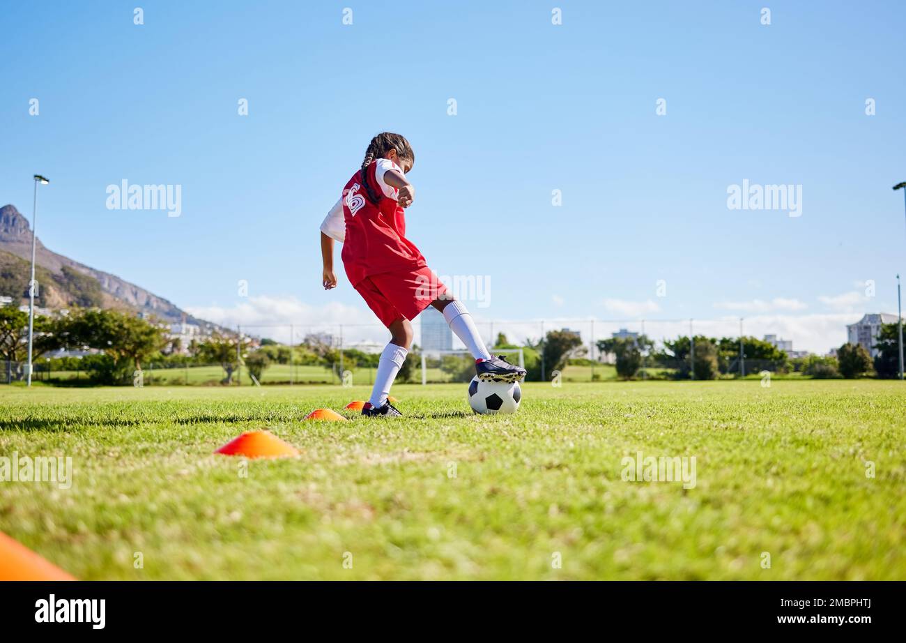 Fußball-Mädchen Kind, Spielfeld und Training für Fitness, Sport und Balance für Kontrolle, Geschwindigkeit und starken Körper aus niedrigem Winkel. Weibliches Kind, schneller Football Stockfoto