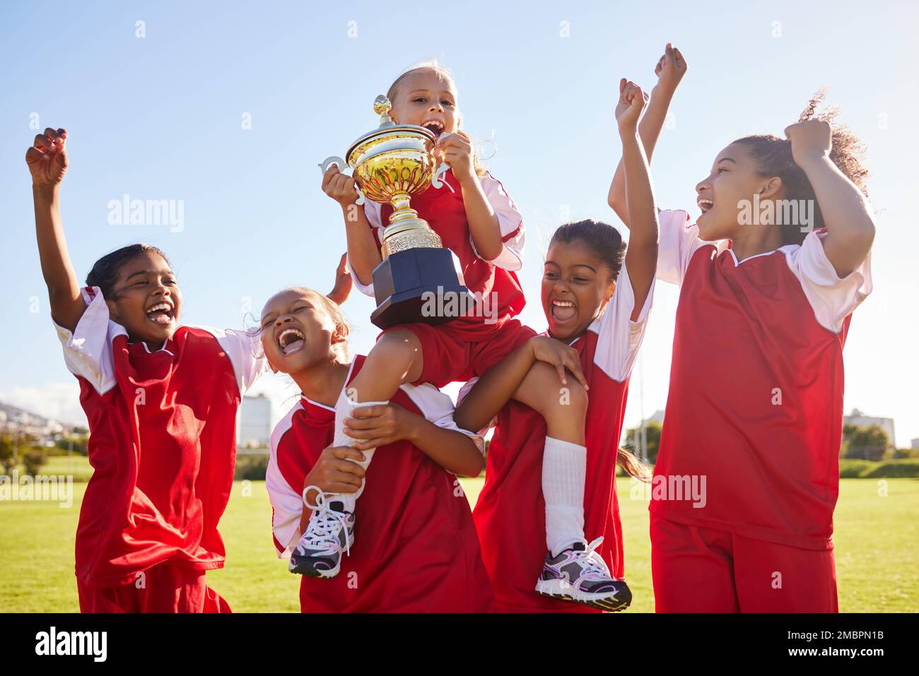 Fußball, Team und Trophäe mit Kindern, die gemeinsam als Siegergruppe für einen Sportwettbewerb feiern. Fußball, Teamwork und Auszeichnung Stockfoto