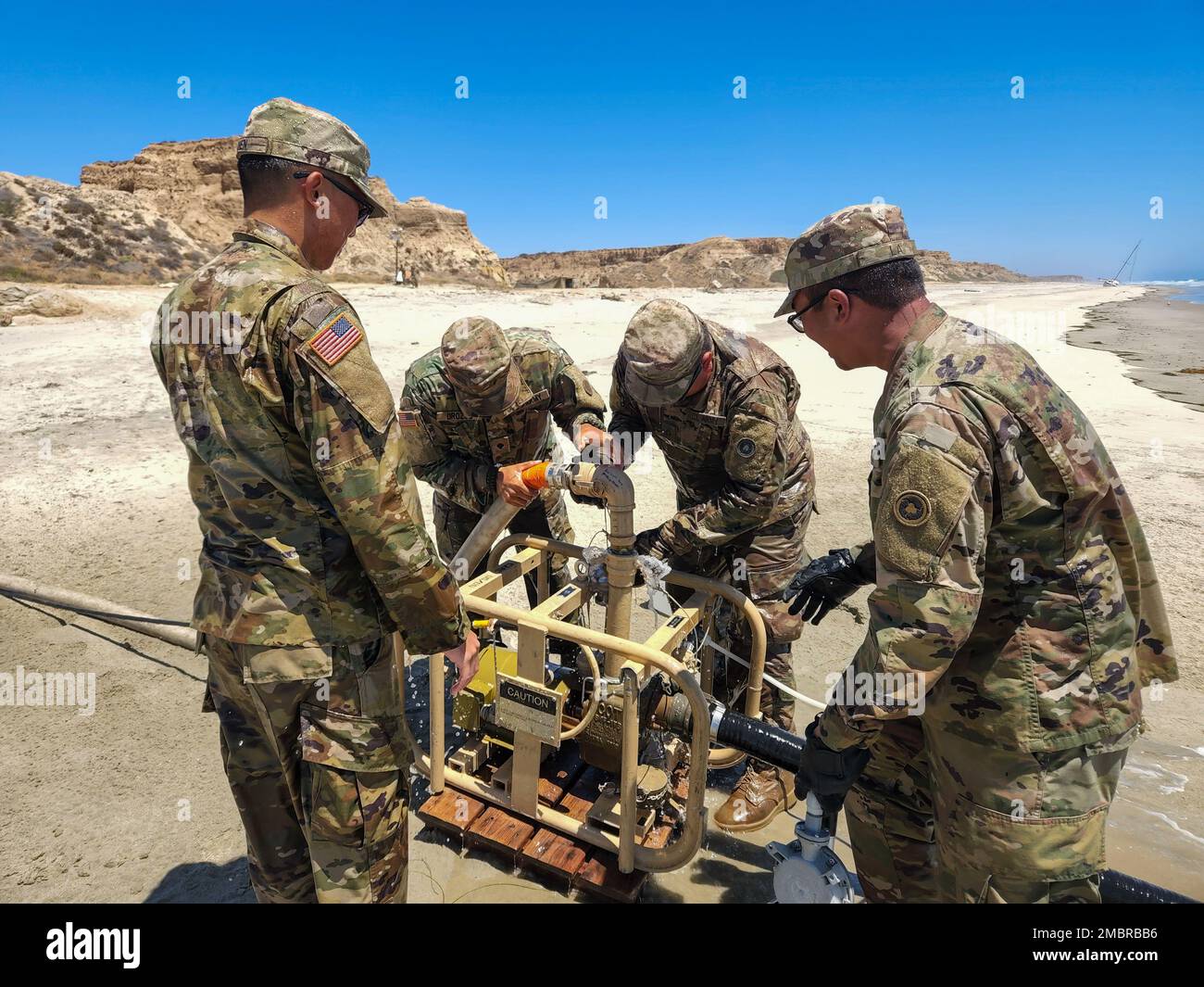 USA Army Reserve Soldaten der 968. Quartermaster Company mit Sitz in Tustin, Kalifornien, bereiten am 20. Juni eine Rohwasserpumpe im Rahmen der Quartermaster Liquid Logistics Übung in Camp Pendleton, Kalifornien, vor. Die Pumpe wird verwendet, um Wasser aus dem Pazifischen Ozean zu ziehen und es in eine Umkehrosmose-Wasseraufbereitungseinheit zu bringen, die das Wasser reinigt und es für Soldaten, die am QLLEX teilnehmen, trinkbar macht. Stockfoto