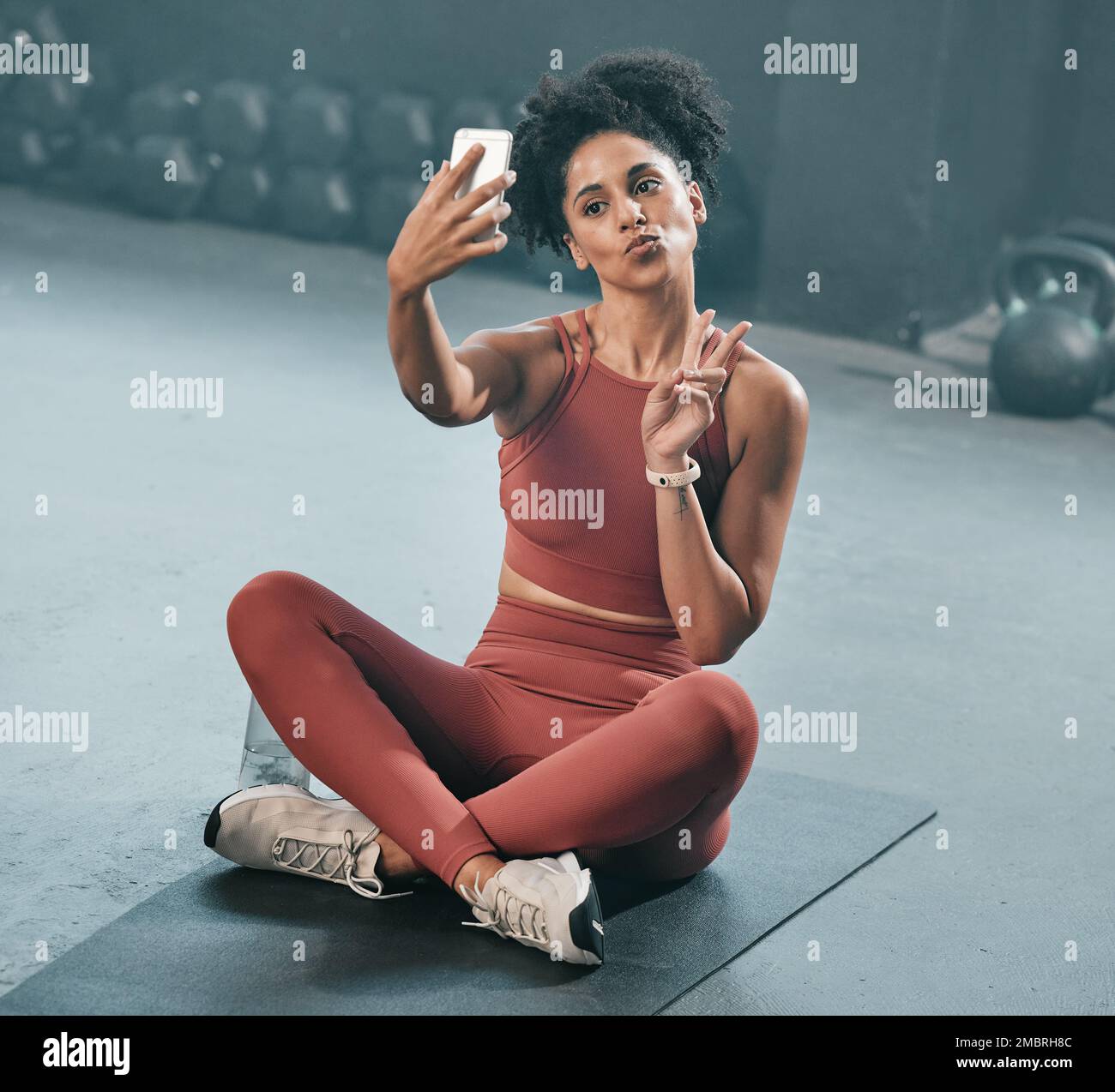 Fitness, Selfie und Frau auf einer Fitnessetage mit Telefon, Ruhe- und Handzeichen vor dem Training. Workout, Bild und Friedensgeste einer schwarzen Frau Stockfoto