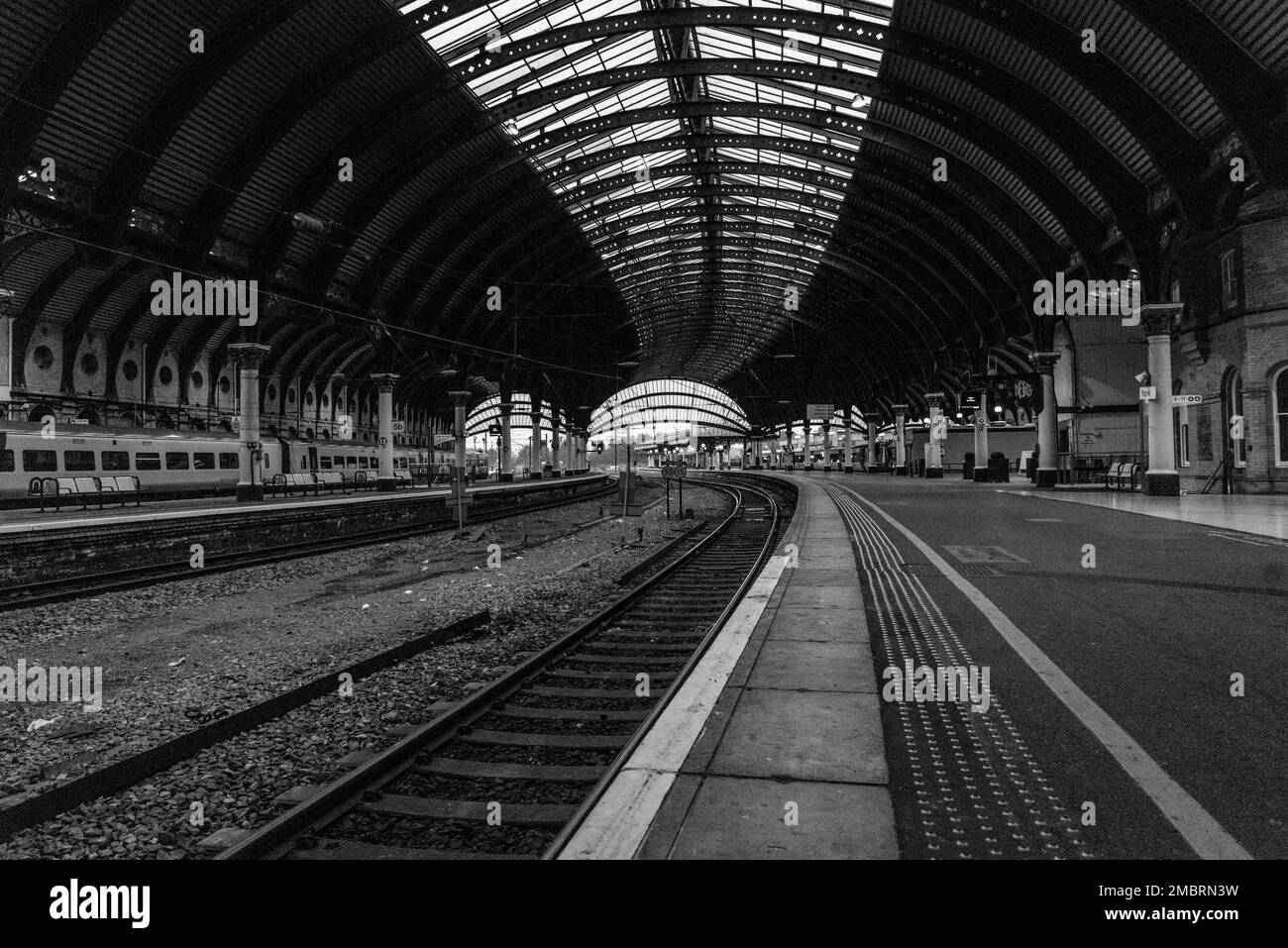 Eine Grauskala des Innenraums eines leeren Bahnhofs Stockfoto