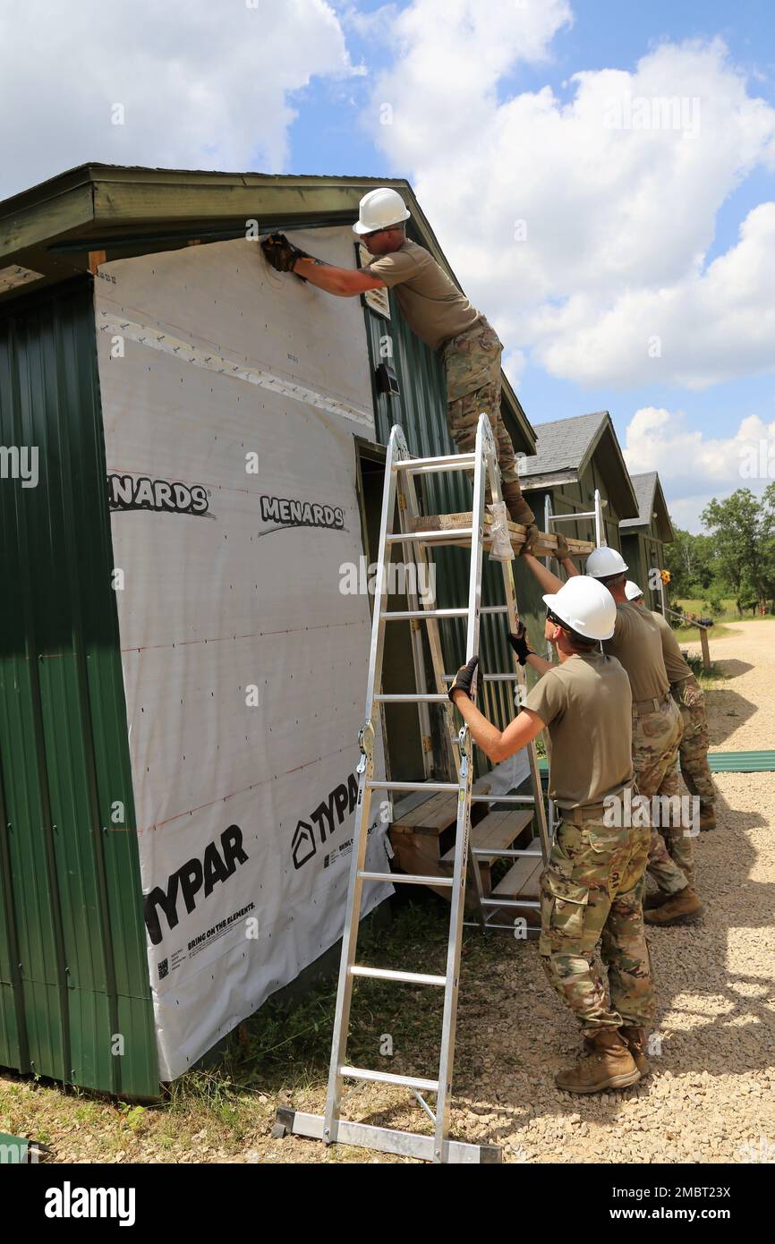 Soldaten der 389. Engineer Company des Army Reserve in des Moines, Iowa, arbeiten am 21. Juni 2022 an einem Truppenprojekt im Camp Courage auf der South Post in Fort McCoy, Wisconsin. Das Unternehmen arbeitete im Rahmen seiner jährlichen Schulung 2022 an mehreren Projekten zur Verbesserung des Lagers, einschließlich der Montage neuer Metallverkleidungen an zahlreichen Gebäuden. Die Truppenprojekte werden von der Direktion für öffentliche Arbeiten von Fort McCoy koordiniert und tragen zur Verbesserung der Infrastruktur der Anlage bei, während gleichzeitig die Ausbildung von Armeeingenieureinheiten stattfindet. Stockfoto